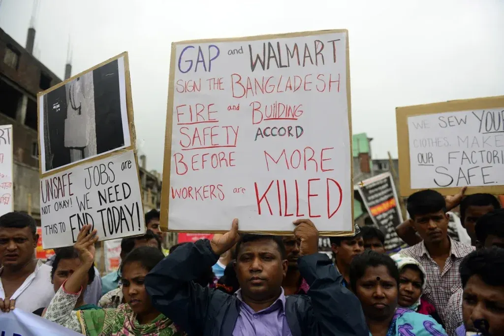 Garment workers in Bangladesh holding protest signs demanding factory safety